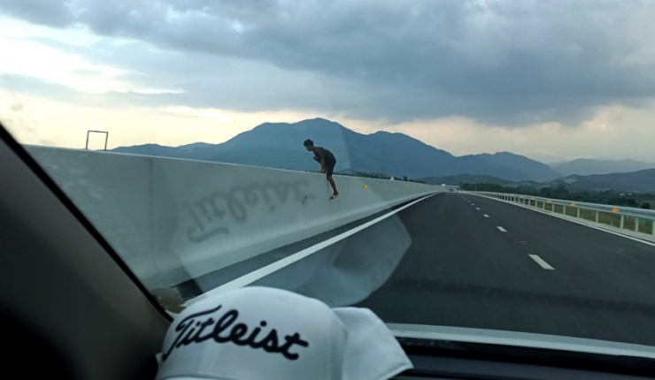 Chạy bộ băng qua cao tốc đoạn Nha Trang - Cam Lâm trước đầu ôtô vào chiều 19-5. Ảnh cắt từ clip.