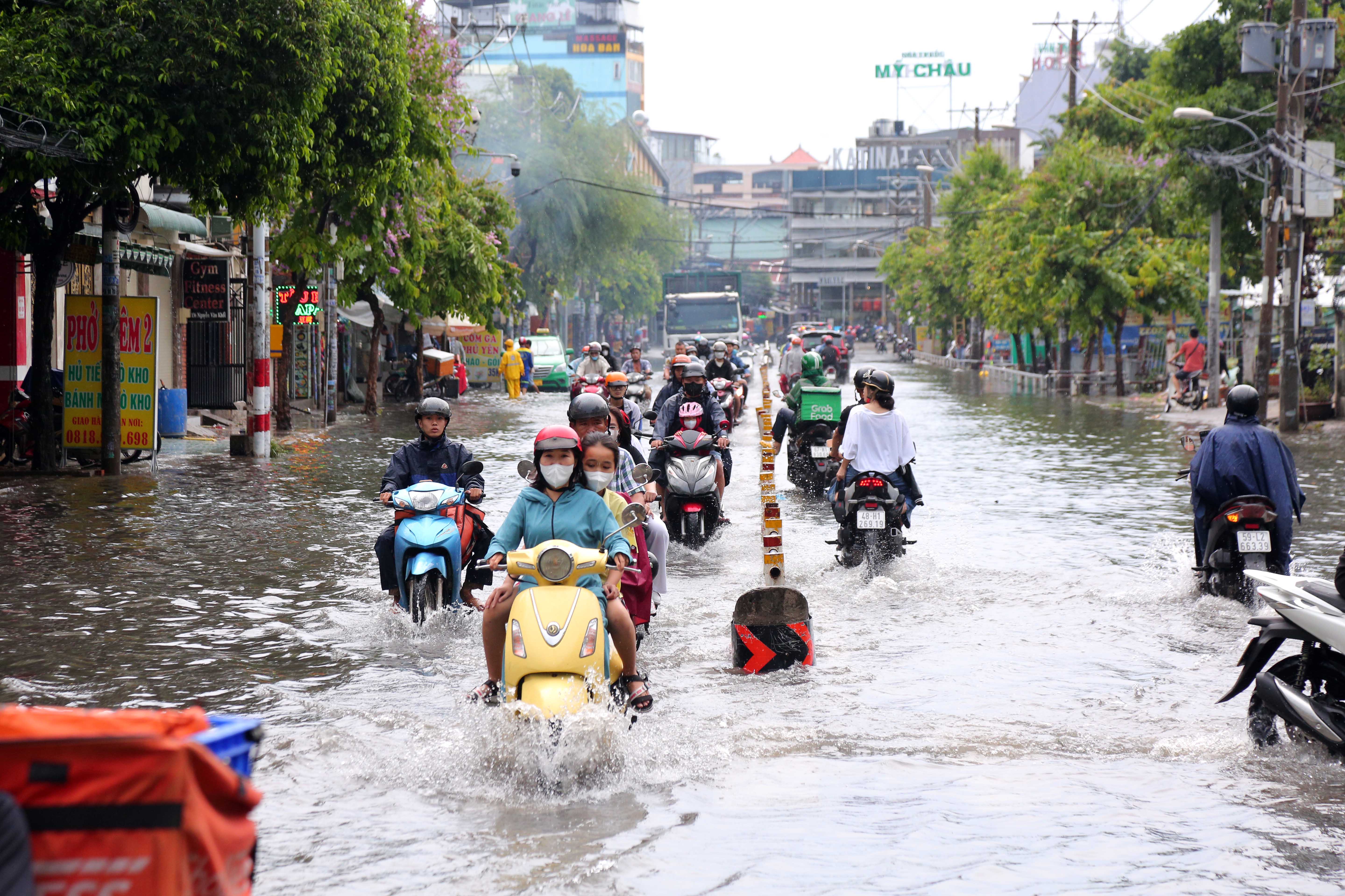 Mưa lớn sau chuỗi ngày nắng nóng, người dân TP.HCM lại bì bõm lội nước vì đường ngập - 1