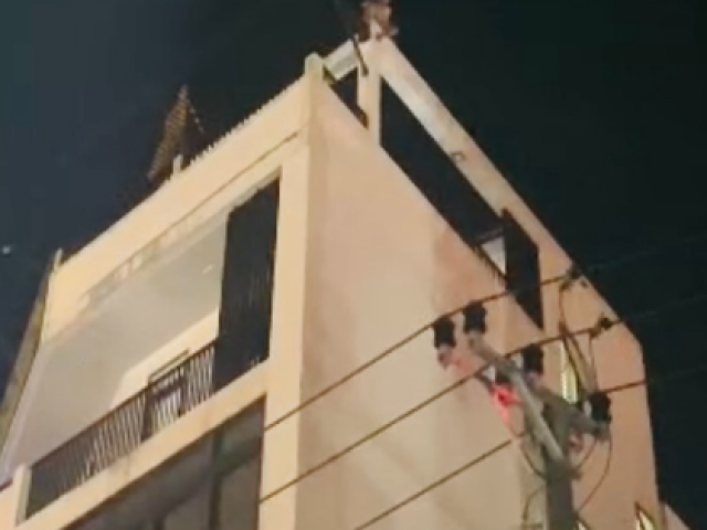 Pháp luật - Một người có biểu hiện mất kiểm soát ngồi trên nóc tòa nhà 4 tầng