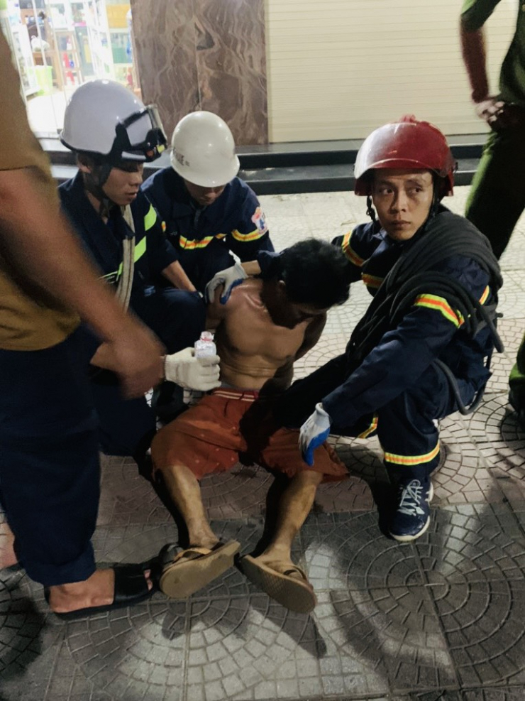 Lực lượng chức năng tiếp cận, đưa nam thanh niên xuống mặt đất an toàn. (Ảnh: Phòng PCCC&CNCH)