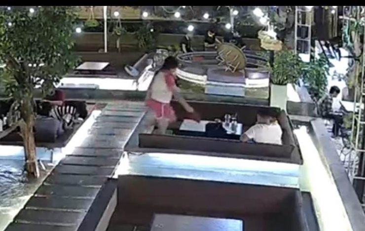 Sau khi nhặt chiếc bóp, bé gái đem về bàn chỗ người đàn ông ngồi. Ảnh: Cắt từ clip