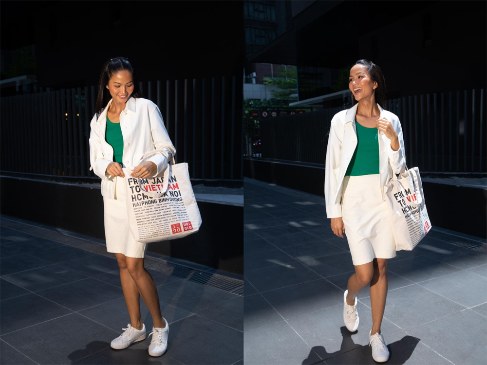 H’Hen Niê diện áo tank top, khoác ngoài là áo khoác vải jersey dáng relaxed cùng với chân váy midi. Set đồ mang tông màu xanh phối cùng màu trắng tạo cảm giác nữ tính, hiện đại phù hợp cho những cô nàng công sở với tiêu chí năng động, thanh lịch. Đương nhiên, không thể thiếu chiếc túi UNIQLO với khả năng cân mọi trang phục.