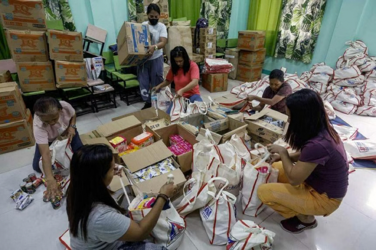 Nhân viên phúc lợi xã và tình nguyện viên chuẩn bị hàng cứu trợ cho những người có thể di tản khỏi bão siêu bão Mawar ở TP Quezon, Metro Manila – Philippines vào ngày 27-5. ẢNH: EPA-EFE