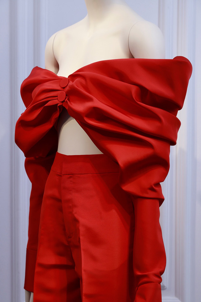 Ekip của người đẹp đã chọn một mẫu áo quây đỏ rực từ BST FW/2023 của người anh Cả Thời trang Việt, kết hợp cùng quần đen ống đứng theo phong cách menswear.