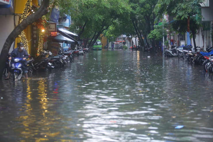 Ghi nhận của PV, vào khoảng 11h30, trận mưa lớn xối xả kèm sấm sét đã khiến nhiều tuyến phố như Vương Thừa Vũ, Láng, Tô Vĩnh Diện, Khương Trung, Bùi Xương Trạch nhanh chóng chìm trong "biển nước" chỉ sau 30 phút.