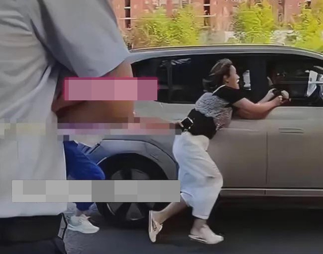 Người phụ nữ bám theo xe chồng sau khi phát hiện chồng chở 'tiểu tam' trên phố. Ảnh cắt từ video
