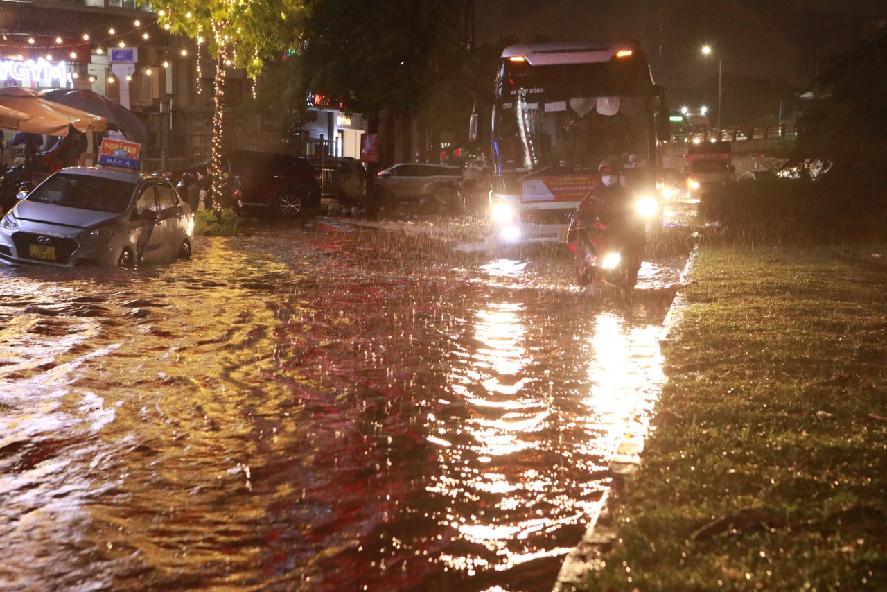 Hà Nội đón &#34;mưa vàng&#34;, nước ngập đường, tràn vào showroom ô tô - 1
