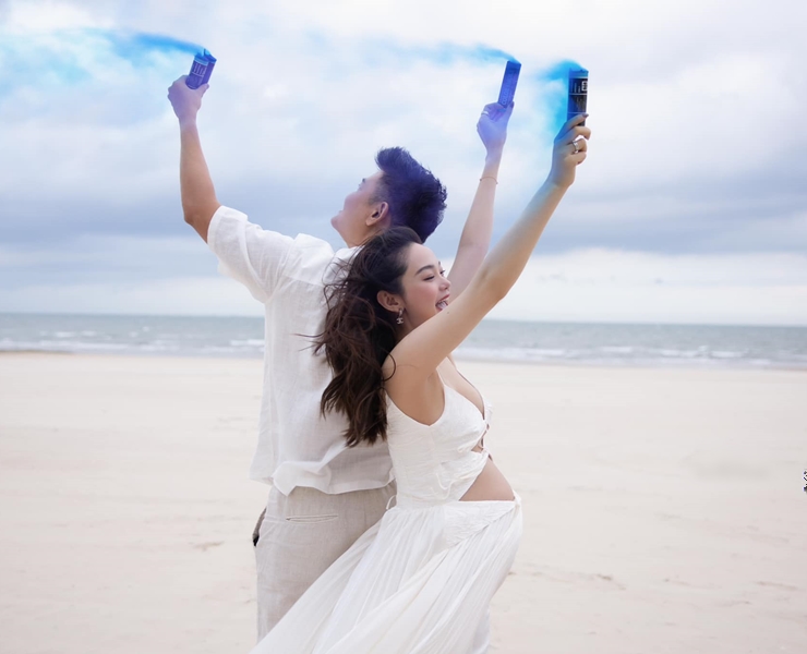 Minh Hằng và chồng mặc đồ trắng, ghi lại những khoảnh khắc hạnh phúc ở bãi biển.