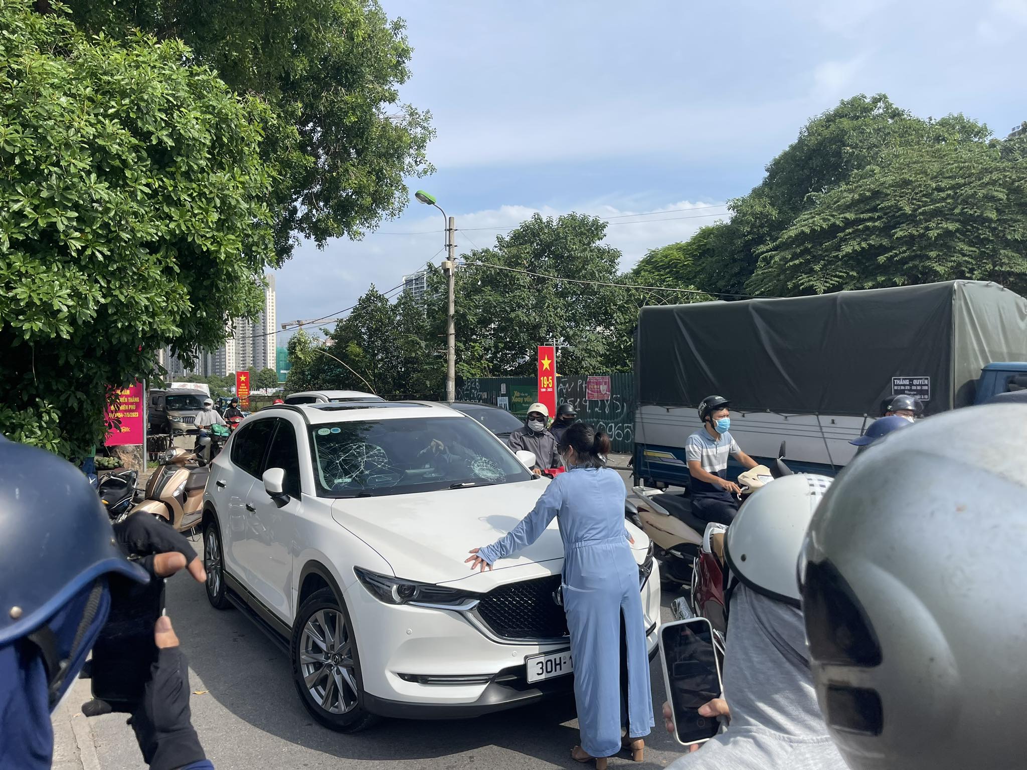 Người phụ nữ chặn đầu ô tô.