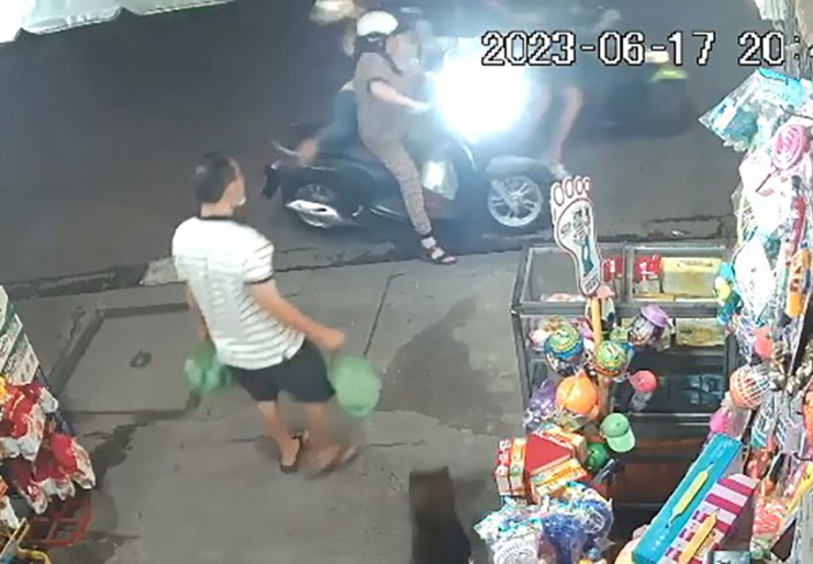 Chị T đang đứng chờ mua hàng thì bị hai thanh niên áp sát, cướp giật điện thoại. Ảnh cắt từ clip