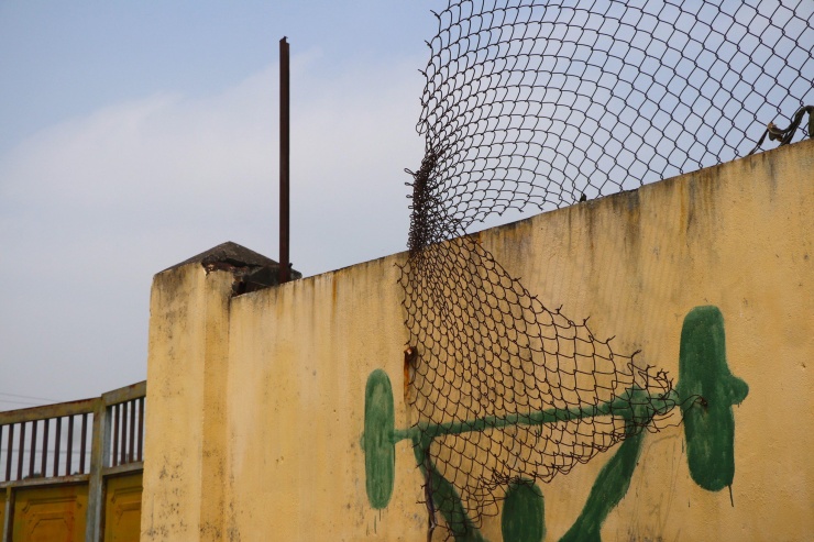 Những cánh cửa ra vào sân và hàng rào sắt hỏng hóc, rỉ sét, nhuốm màu thời gian.