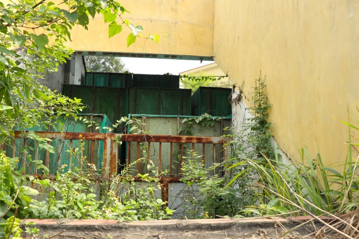 Khu vực dưới hầm khán đài phía cổng phụ đi vào nhếch nhác, cây dại mọc um tùm được trưng dụng làm nơi tập kết những bồn, bục, bệ không sử dụng.