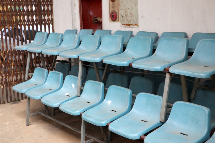 Hàng ghế khán đài đã mục, bay hết màu sắc.