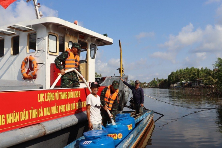 Người dân Cà Mau vui mừng nhận nước sạch từ 3 tàu chở nước hỗ trợ hạn hán của Quân khu 9. Ảnh: CTV