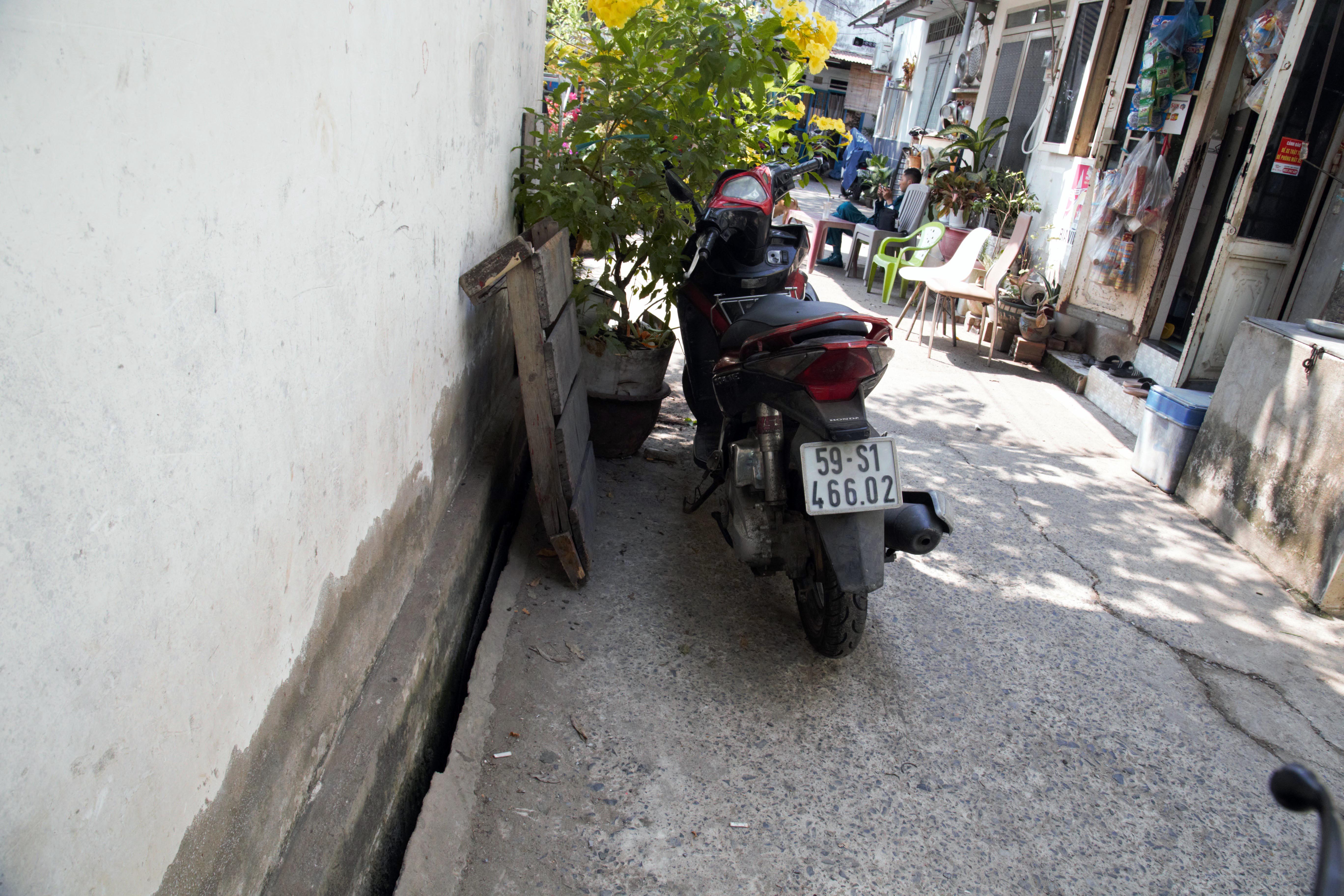 Nhiều căn nhà bị sụp và nghiêng ra phía bờ kênh tạo thành khoảng hở so với mặt đường trong hẻm. “Nhà tôi cũng bị ảnh hưởng, nứt tường và nền nhà nhưng không trong diện di dời. Buổi tối, nằm trong nhà mà cứ nghe tiếng rắc rắc của sạt lở. Từ khi xảy ra sạt lở tới giờ, gia đình tôi ngủ không dám đóng cửa. Cửa chỉ chốt một cánh thôi à, để phòng có chuyện gì thì cả nhà còn chạy kịp. Ngủ mà cứ lo sợ “hà bá” nuốt nhà không à”, bà Nguyễn Thị Trắng (70 tuổi) cho biết.