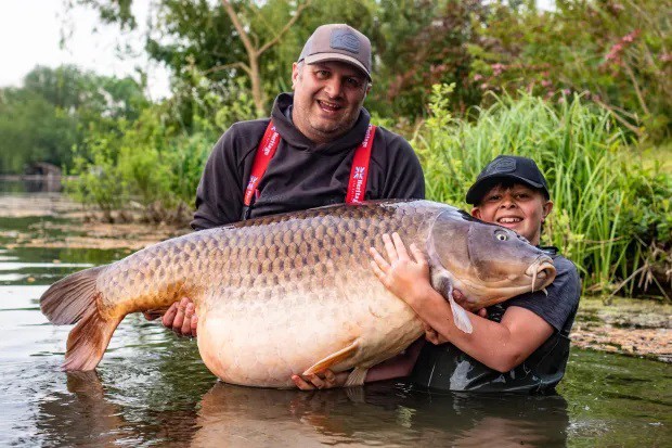 Callum và bố chụp ảnh cùng con cá chép nặng gần 45kg