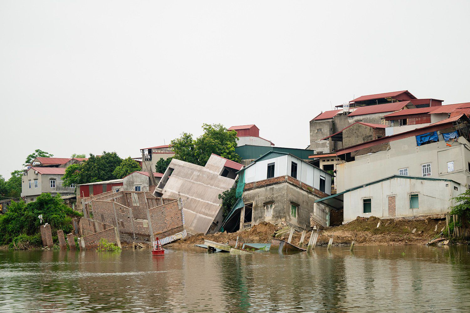 Những ngôi nhà bị sạt lở xuống sông