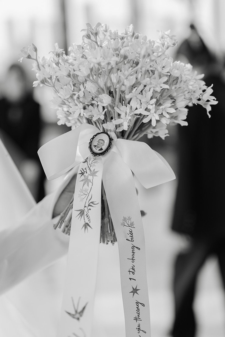 Minh Tú đặt di ảnh của người ba quá cố lên bó hoa cưới cầm tay.