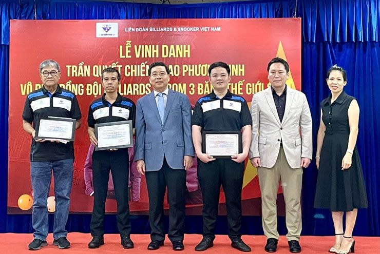 Lễ vinh danh Quyết Chiến (thứ 2 từ trái sang) và Phương Vinh (thứ 3 từ phải sang) cùng HLV Việt Hòa (ngoài cùng bên trái)