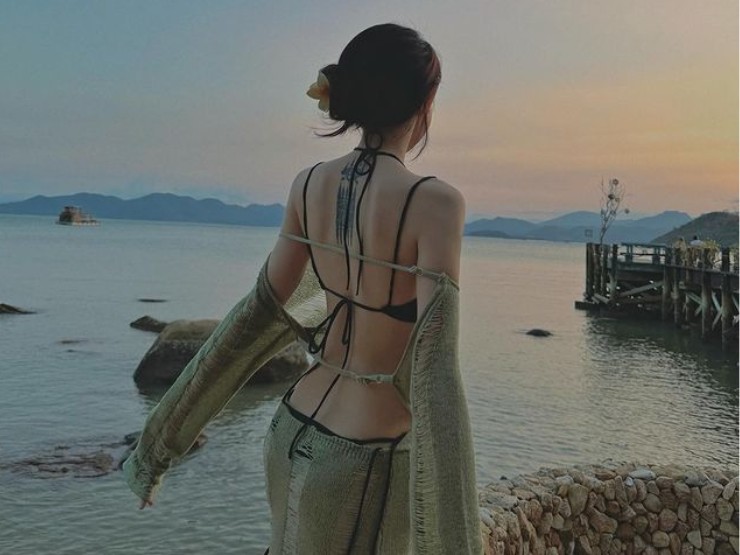 Cô nàng lựa chọn áo tắm màu đen phối bên ngoài váy xuyên thấu, với khoảng hở lưng lớn.
