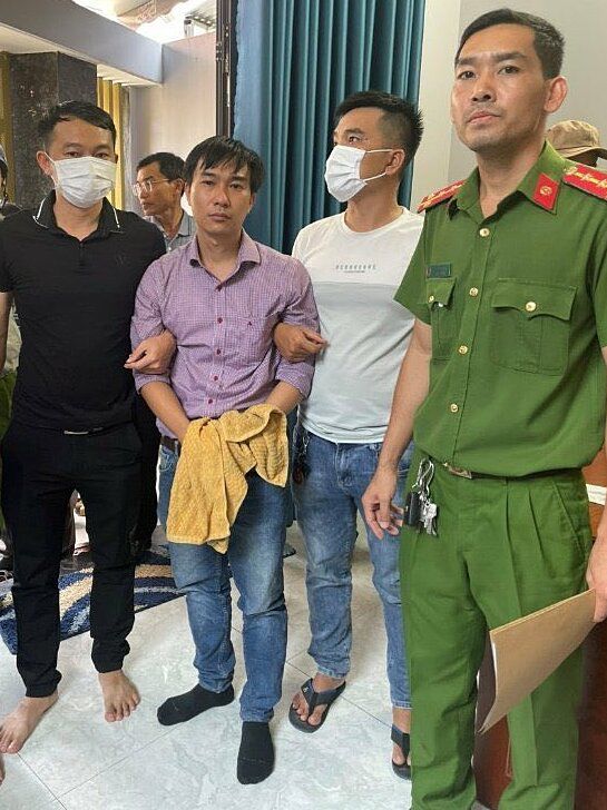  Bác sĩ Danh Sơn (áo sơ mi) khi bị bắt.  