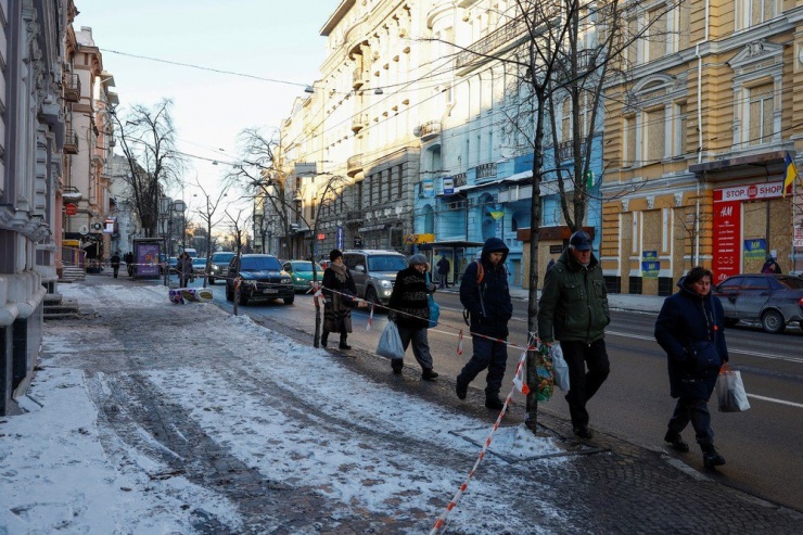 Người dân đi dọc con phố cạnh các tòa nhà lịch sử bị hư hại vì một trong những cuộc tấn công bằng UAV của Nga ngày 13-1. Ảnh: Valentyn Ogirenko/REUTERS
