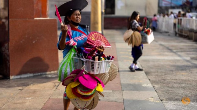 Một người bán quạt bên ngoài nhà thờ Quiapo trong ngày nắng nóng ở Manila, Philippines. (Ảnh: Reuters)