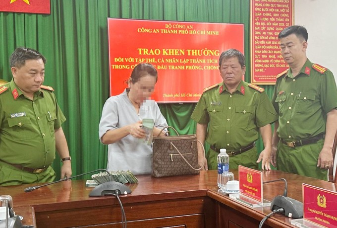 Công an TP HCM trao trả túi tiền 1,1 tỷ đồng cho bà chủ biệt Thự. Ảnh: Quốc Thắng