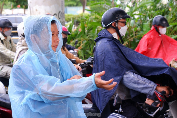 Cơn mưa lớn bất chợt khiến nhiều người đi đường phải dừng xe trên đường Võ Văn Kiệt (quận 1) để mặc áo mưa.