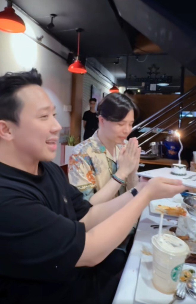 Khi Trịnh Thăng Bình thổi nến, Hari Won đích thân quay clip lại còn Trấn Thành vừa cầm bánh kem vừa hát mừng.