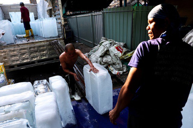Người dân dỡ đá lạnh từ xe tải tại chợ ở thủ đô Bangkok - Thái Lan hôm 2-5 Ảnh: REUTERS