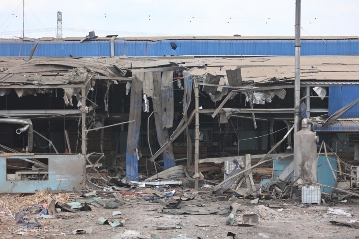 Một phần dãy tường nhà xưởng dựng bằng tôn dài khoảng 100 m, cao gần 5 m biến dạng hoàn toàn.