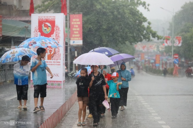 Khoảng 6h50, trời đổ mưa lớn, nhiều em nhỏ, người dân, cựu chiến binh vẫn mang ô, áo mưa đổ về khu vực trước sân vận động tỉnh Điện Biên để chờ xem lễ kỷ niệm 70 năm chiến thắng Điện Biên Phủ.