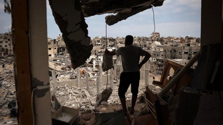 Người dân nhìn ra đống đổ nát ở TP Khan Younis (nam Gaza) hôm 2-5. Ảnh: AFP
