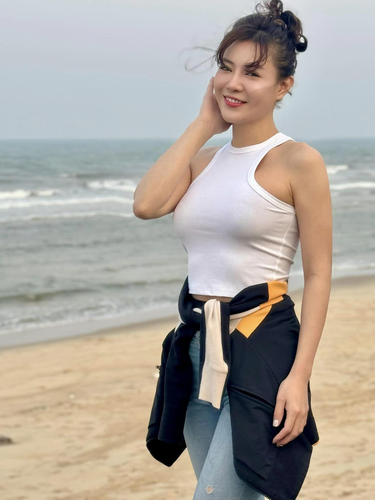 Thanh Hương phối áo thun cùng quần jeans đơn giản khi đi biển.