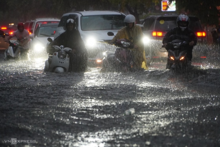 Tại khu Thảo Điền ở TP Thủ Đức, đường mênh mông nước, hàng loạt người hì hục xe chết máy.
