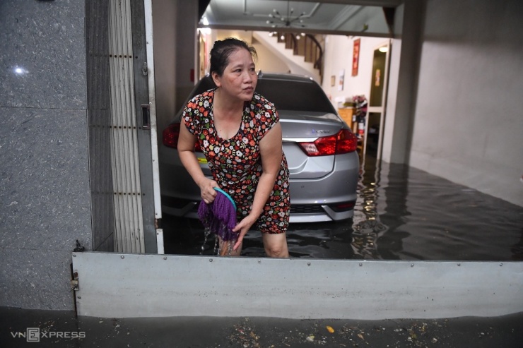 Các hộ dân hai bên đường dùng nhiều vật dụng để ngăn nước tràn vào nhà nhưng không xuể.