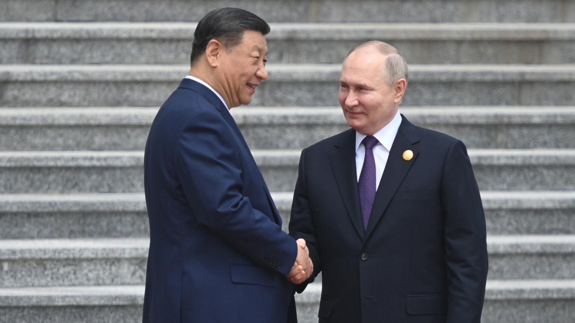 Ông Putin (phải) bắt tay Chủ tịch Trung Quốc Tập Cận Bình trong chuyến thăm Trung Quốc.