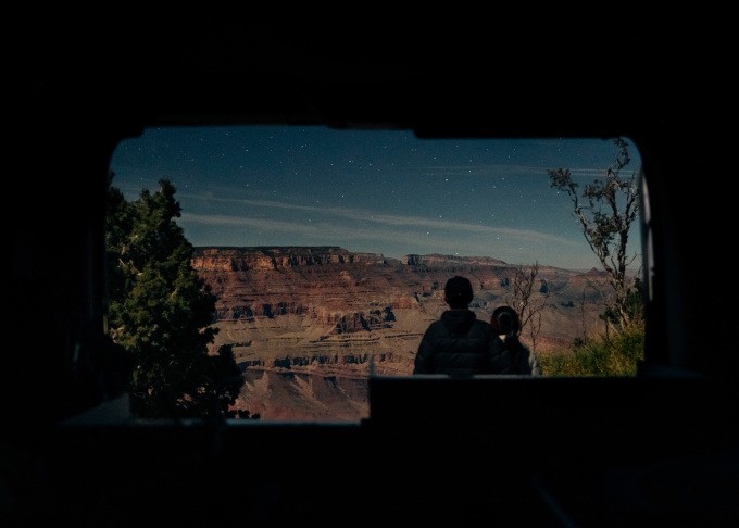Cặp vợ chồng qua cửa chiếc xe tự lái ngắm sao đêm tại hẻm núi Grand Canyon trong chuyến lái xe đi xuyên 23 công viên quốc gia Mỹ. Ảnh: Nhân vật cung cấp