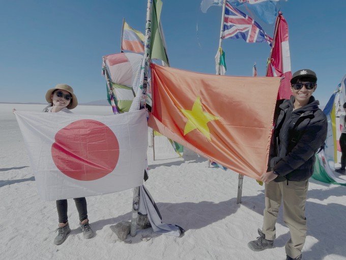 Cặp vợ Nhật chồng Việt bên quốc kỳ hai quốc gia tại Hồ muối Uyuni ở Bolivia, mùa đông 2023. Ảnh: Nhân vật cung cấp