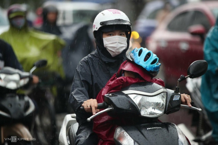 Người mẹ chở con đi học bị kẹt xe do mưa lớn trên đường Đinh Bộ Lĩnh, quận Bình Thạnh.