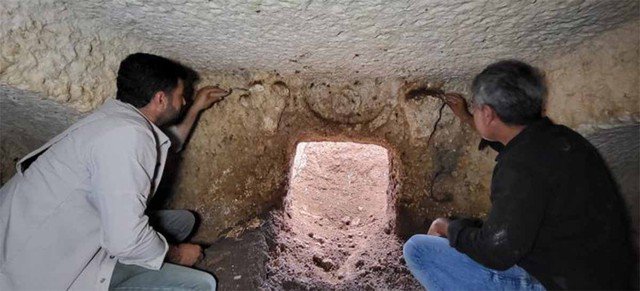 Cửa của cổ mộ đã bị đất đá thu hẹp lại, bên trên là hai chiếc đầu bò đực đã bị hư hại sau 2.000 năm - Ảnh: IHA