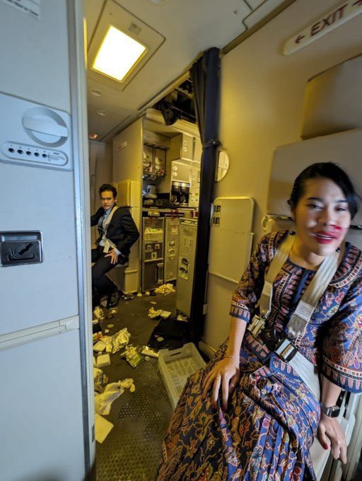 Tiếp viên phi hành đoàn thắt dây toàn trên máy bay Singapore gặp nạn ngày 21/5. Ảnh: Daily Mail
