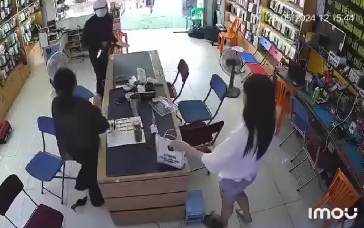 Hình ảnh người đàn ông cầm vật giống dao xông vào cửa hàng. Ảnh cắt từ video clip.