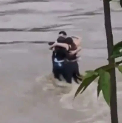 Khoảnh khắc 3 người bạn đứng ôm nhau trước khi bị nước lũ cuốn trôi - 1