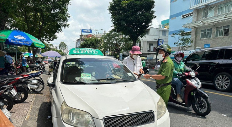 Đội CSGT-TT, Công an quận 3 tuần tra, xử lý việc dừng đỗ sai quy định với một tài xế xe taxi 27-7 ở trước cổng Bệnh viện Tai Mũi Họng. Ảnh: YT