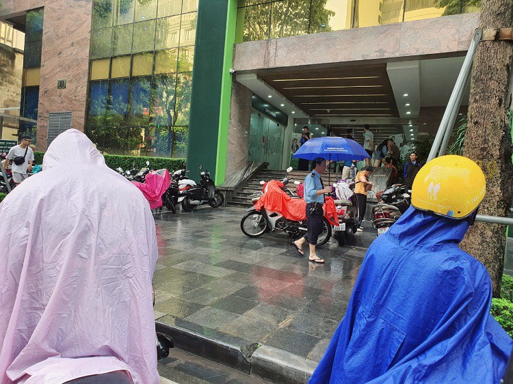 Mưa như trút nước nhưng bãi để xe của ngân hàng Vietcombank ở Láng Hạ không còn chỗ, nhiều người loay hoay tìm chỗ gửi.