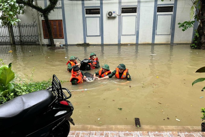 Bộ đội đưa xe máy ngập sâu 1,5 m lên thềm nhà ở TP Hà Giang. Ảnh: Oanh Phạm