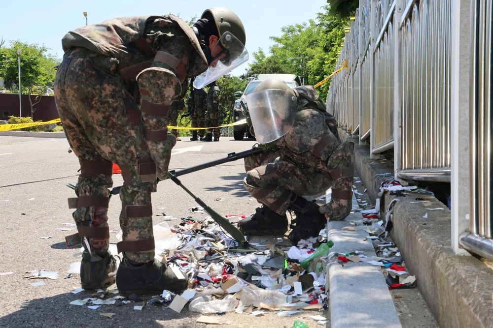 Binh sĩ Hàn Quốc kiểm tra một bong bóng bay chứa rác mà Triều Tiên thả sang. Ảnh: YONHAP