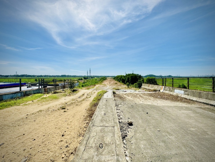 Theo ghi nhận của PV, tại nút giao thông này, đơn vị thi công mới hoàn thành mố trụ, bản mặt 3 cầu bắc ngang qua cao tốc, đường sắt Bắc - Nam và Quốc lộ 1A. Mặc dù đã hoàn thiện khối lượng lớn công việc trên tuyến nhưng nhà thầu đã bỏ dở, dừng thi công dự án suốt nhiều năm qua. Trong khi đó, các hạng mục còn lại của dự án như nhà điều hành, trạm thu phí, đường dẫn vẫn chưa biết ngày nào thi công trở lại. Ảnh: Nguyễn Ngọc.